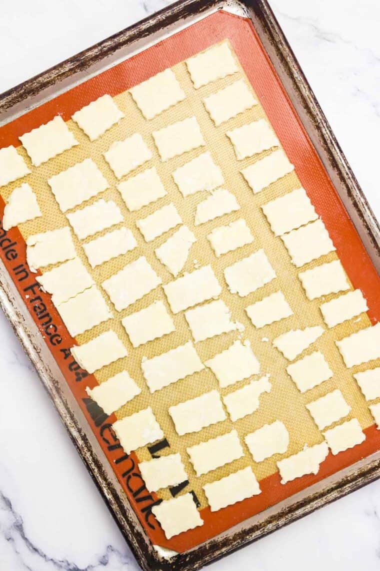 Cut pie crust crackers arranged on a lined baking sheet.