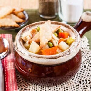 Pie crust crust crackers on the top of a bowl of turkey pot pie soup.