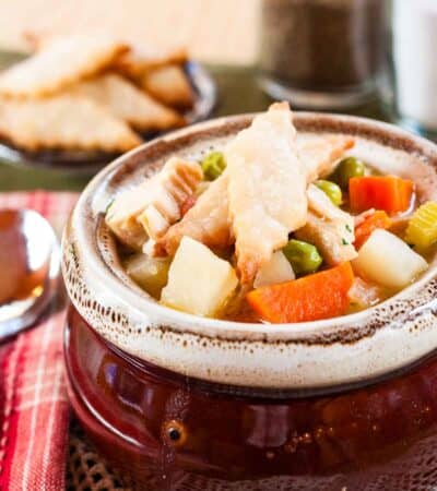 Pie crust crust crackers on the top of a bowl of turkey pot pie soup.