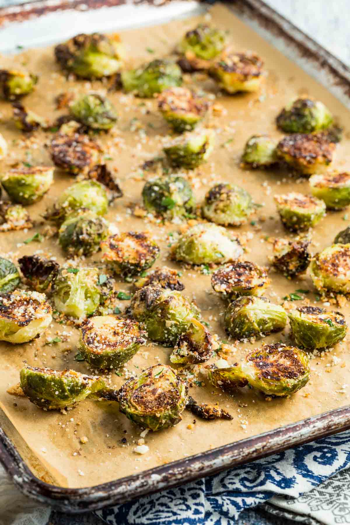 A parchment-lined baking sheet with roasted parmesan Brussels sprouts.