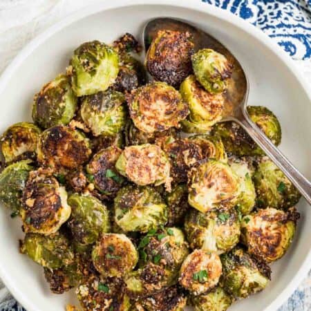 A white serving bowl of Garlic Parmesan Roasted Brussels Sprouts.