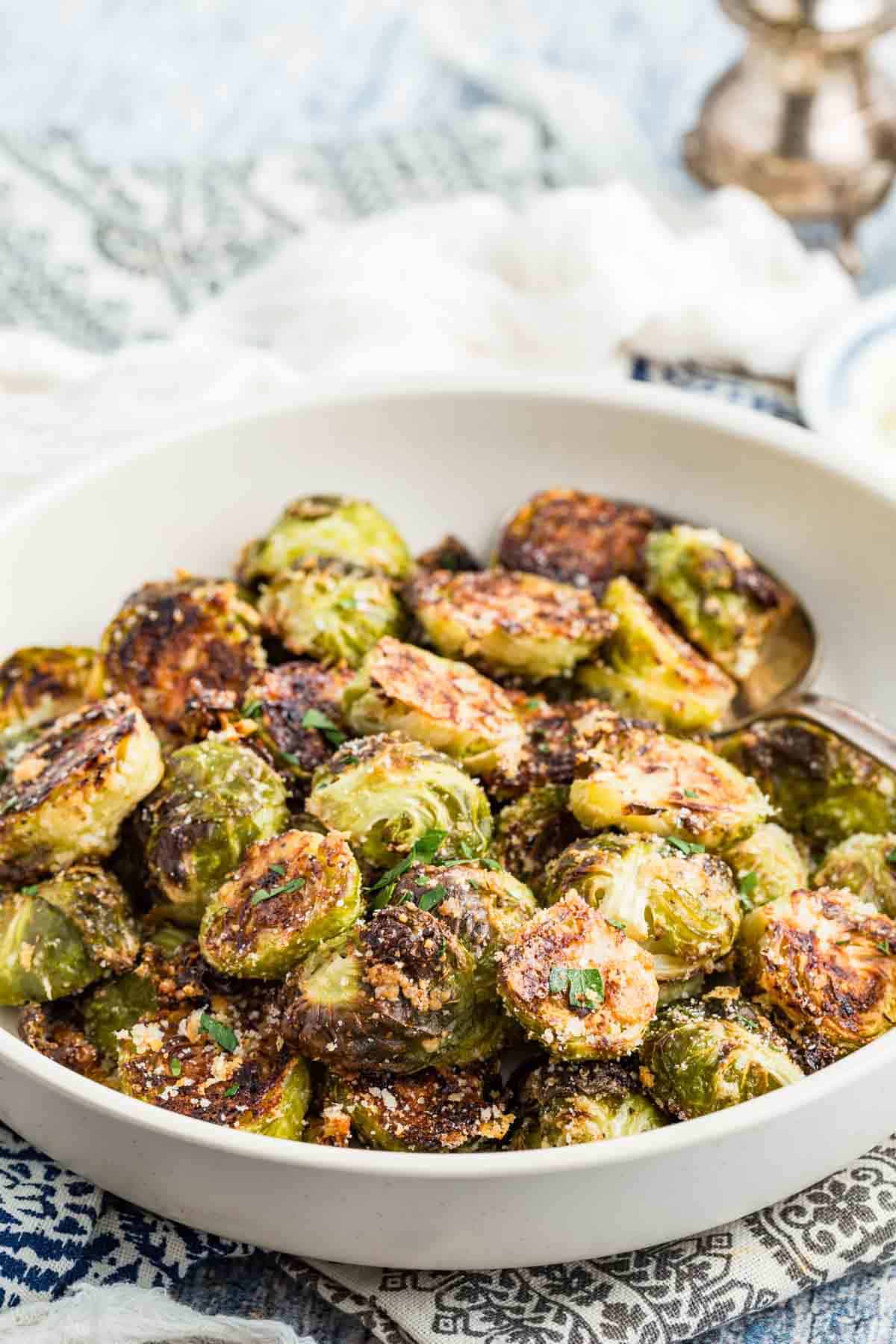 Lightly browned garlic parmesan roasted Brussels sprouts piled into a white bowl.