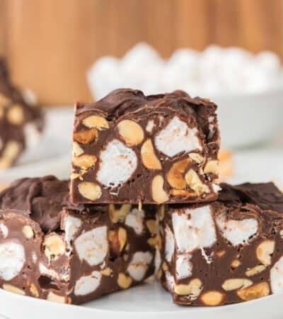Three pieces of rocky road fudge with nuts and marshmallows on a plate.