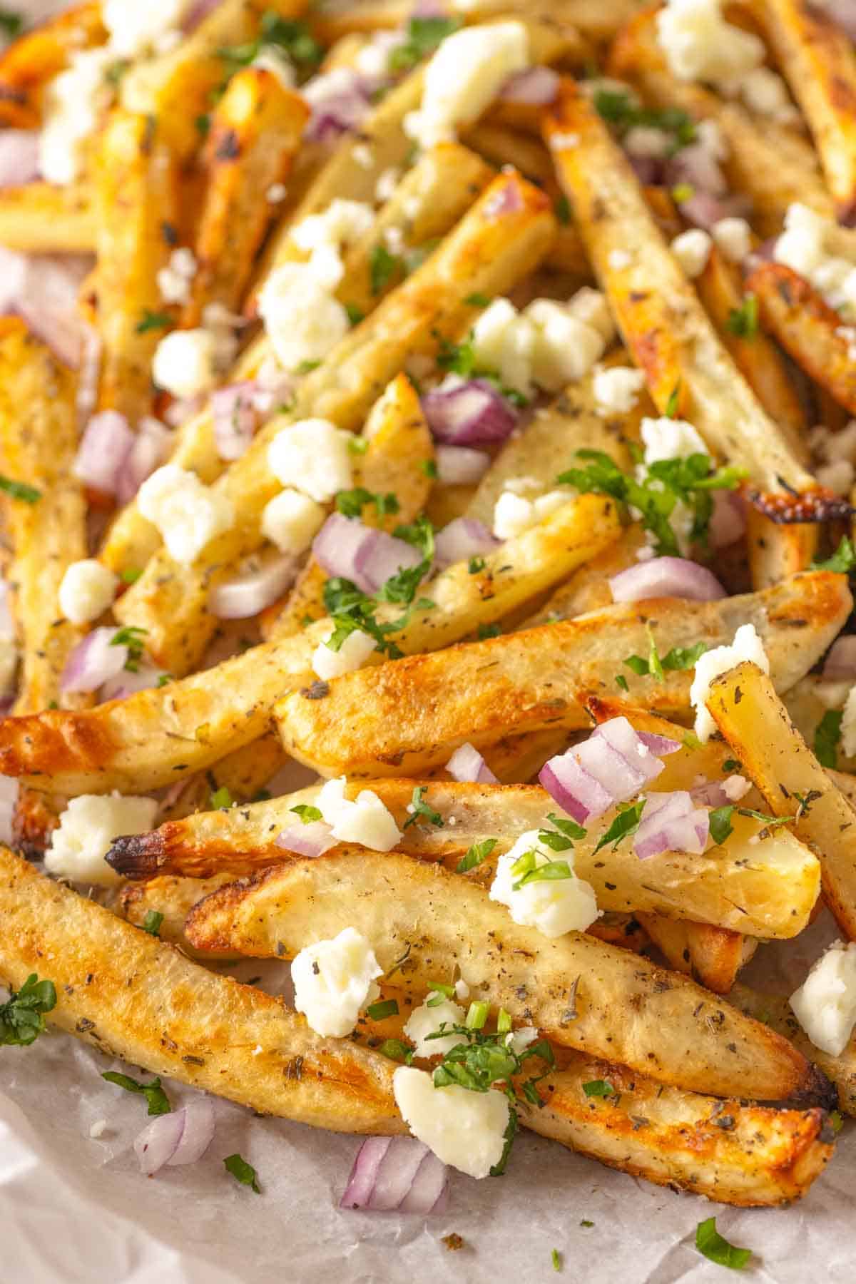 Chopped onions, feta, and parsley on top of Greek fries.