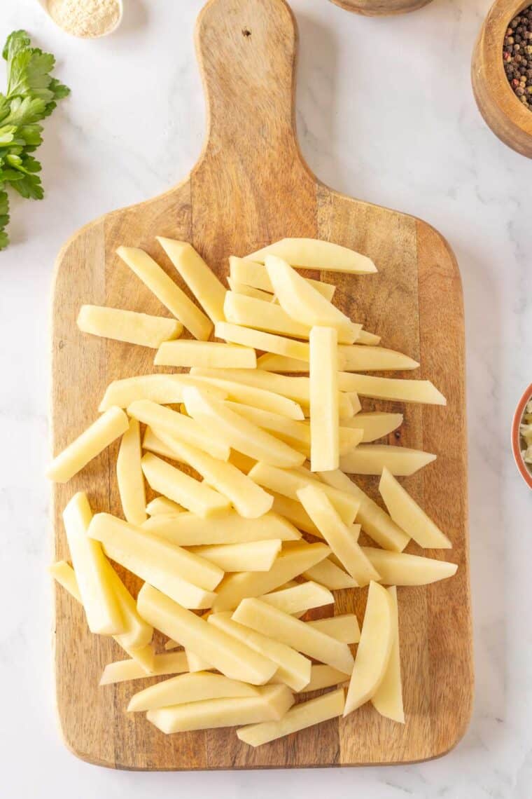 Potato fries on a cutting board.