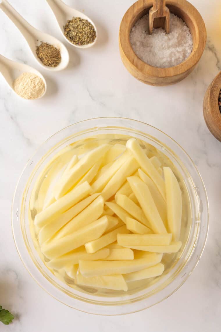 A bowl of potatoes soaks in water.