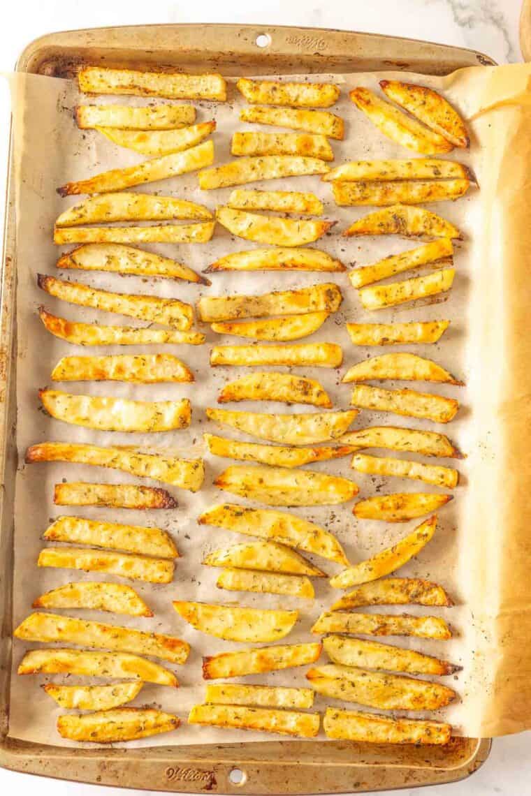 A baking sheet of fries after being baked.