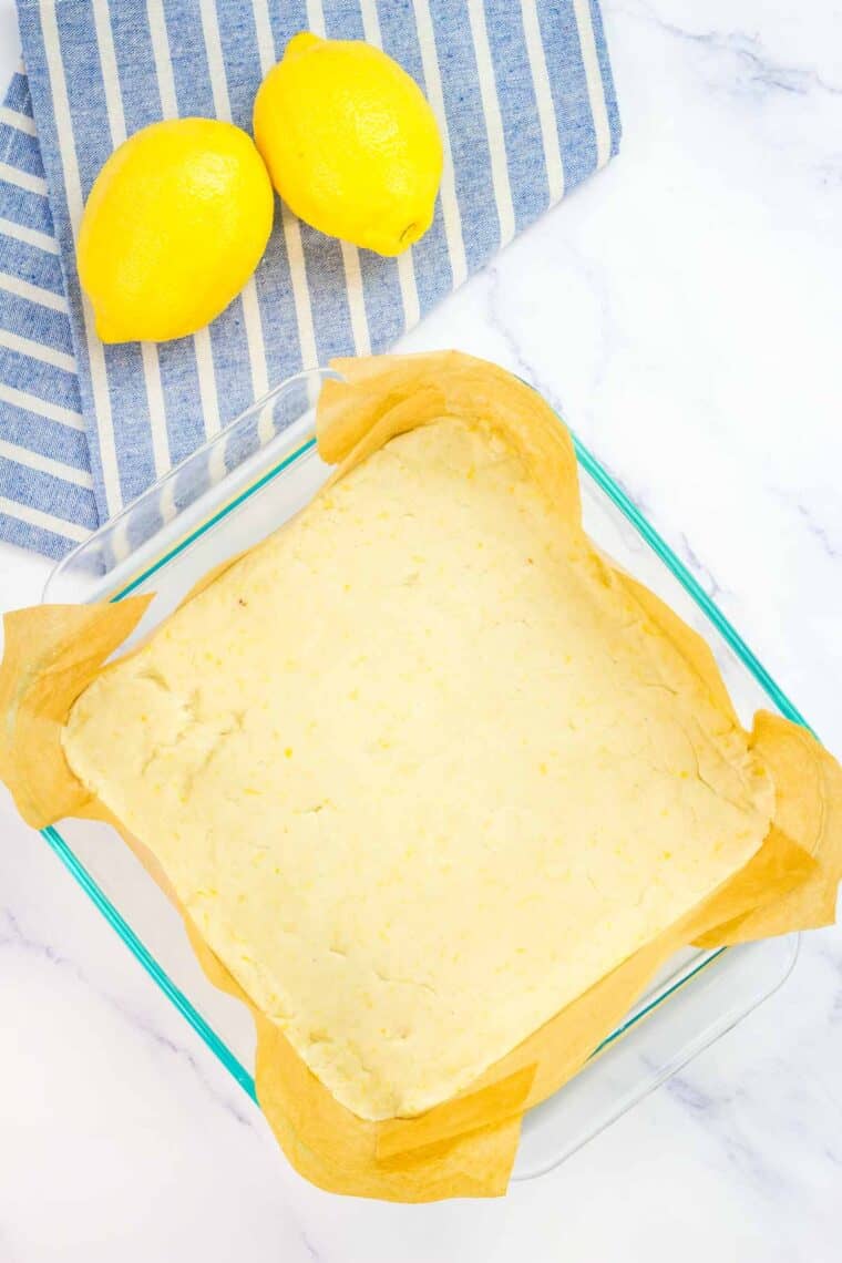 Lemon shortbread dough pressed into a baking pan.