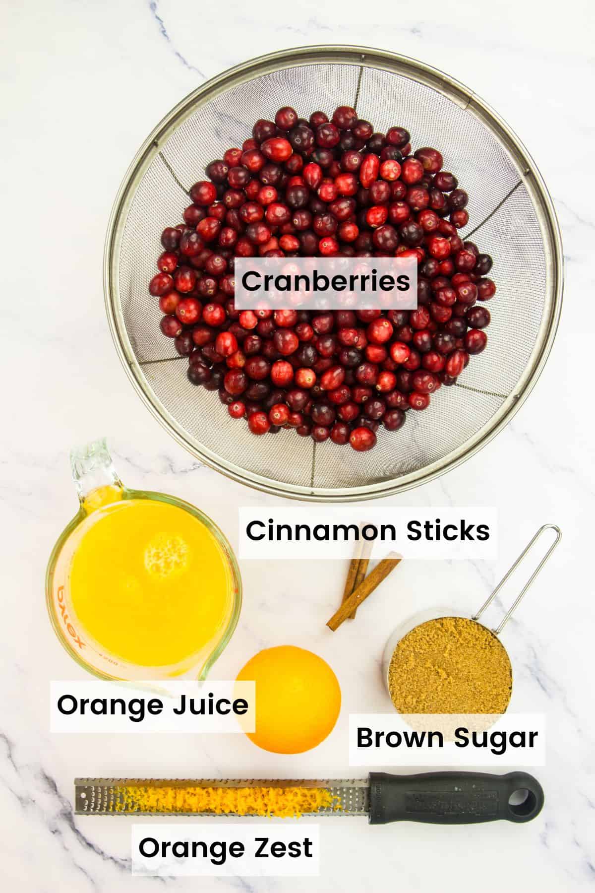 Orange cranberry sauce ingredients on a countertop with text labels.