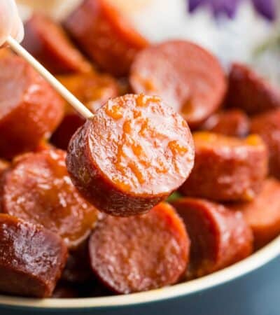 A toothpick holds a slice of slow cooker kielbasa.