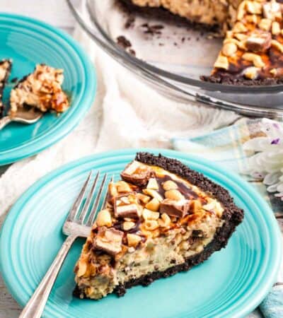 Chopped snickers bars top a slice of snickers pie.