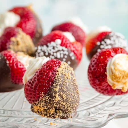 A glass cake plate with deviled strawberries dipped in chocolate.