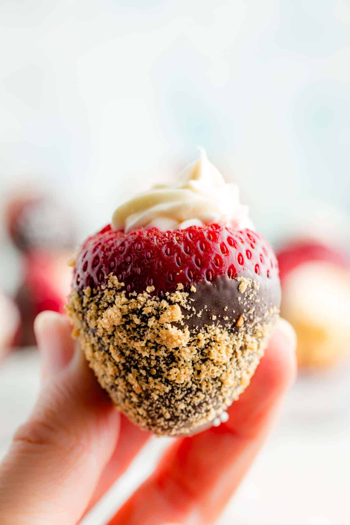 Chocolate and cookie crumbs on a cheesecake stuffed strawberry.