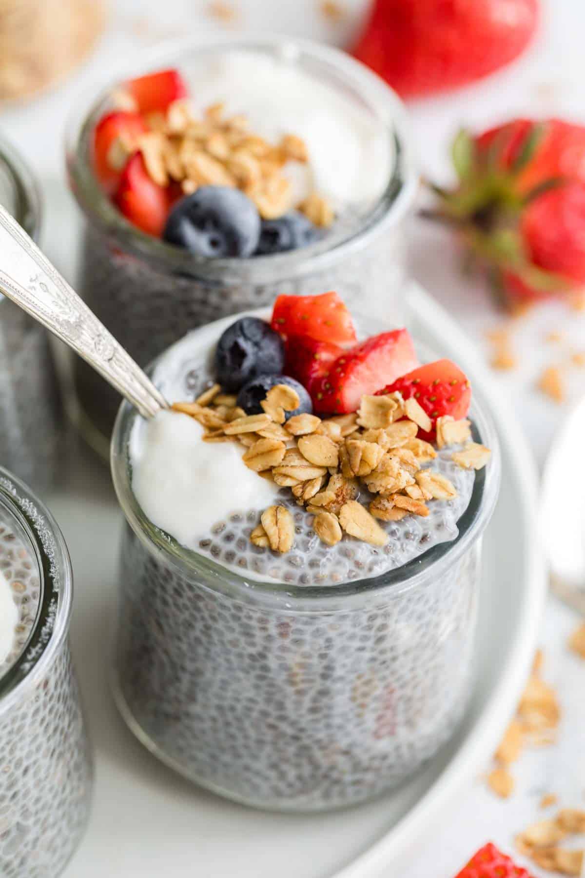 This honey-sweetened Chia Seed Pudding Recipe is a favorite! It's naturally gluten free and you'll just shake together the ingredients and chill for pudding perfection. Granola and berries top a jar of chia seed pudding.