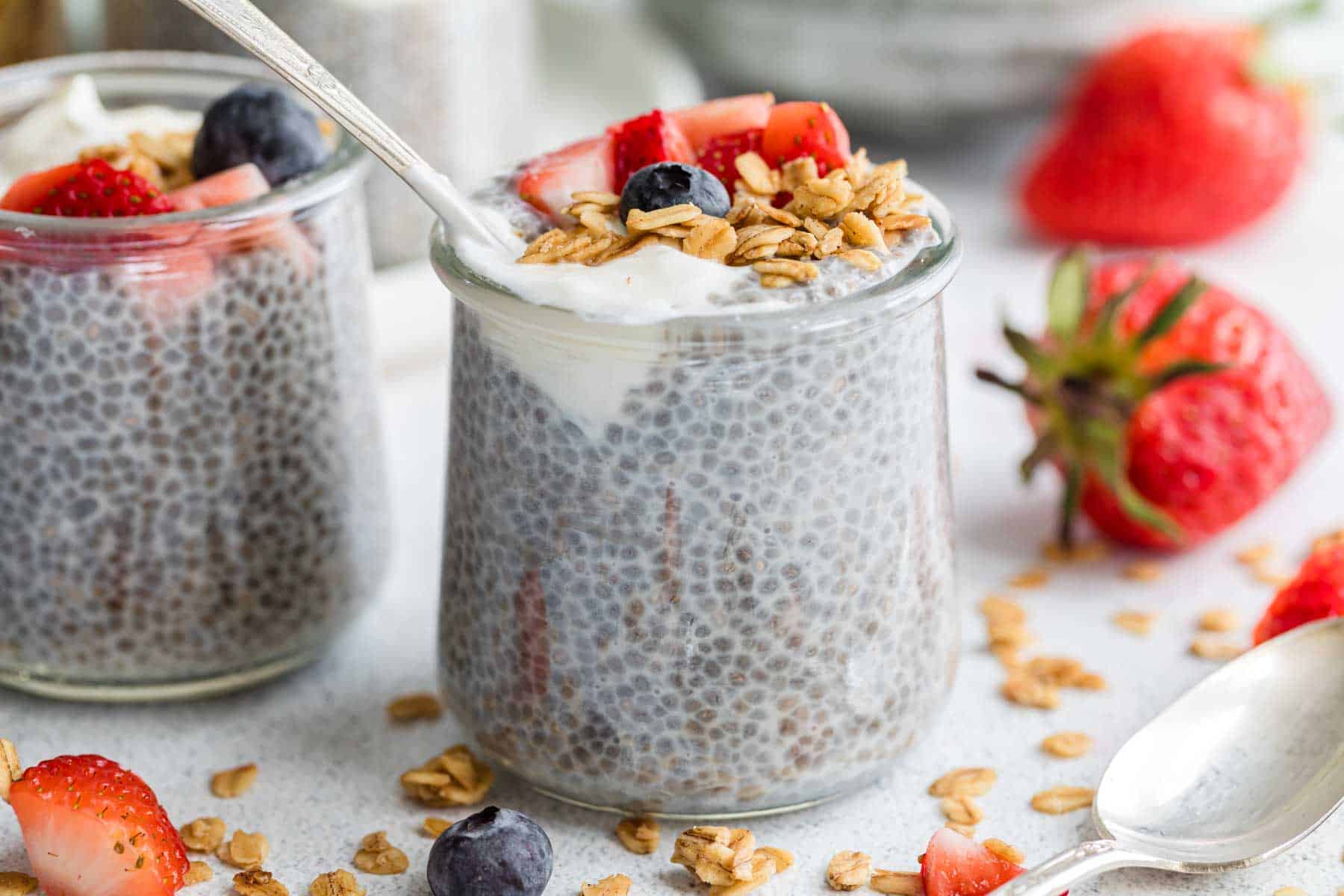 Granola and berries top a jar of chia seed pudding.