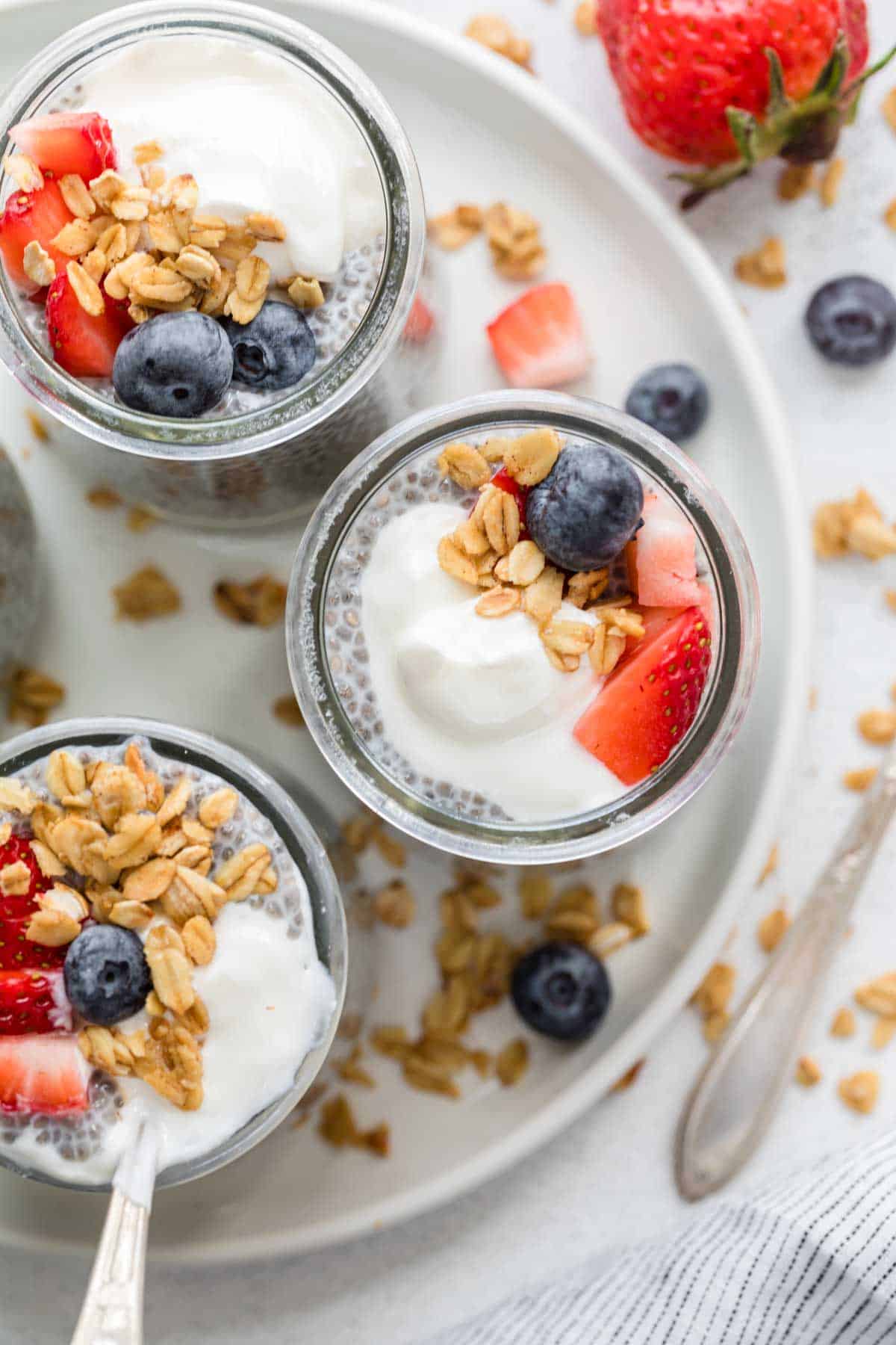 Jars of chia seed pudding and topping arranged on a tray.