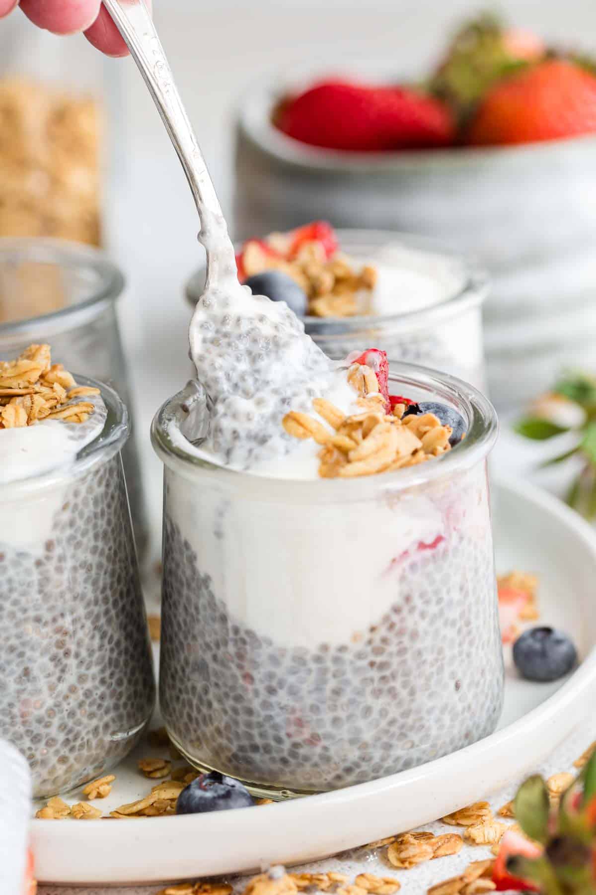 A spoon dips into a jar of chia seed pudding.