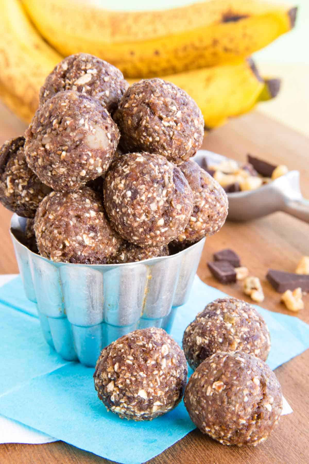 A container of Chunky Monkey banana energy balls with a few in front of it.