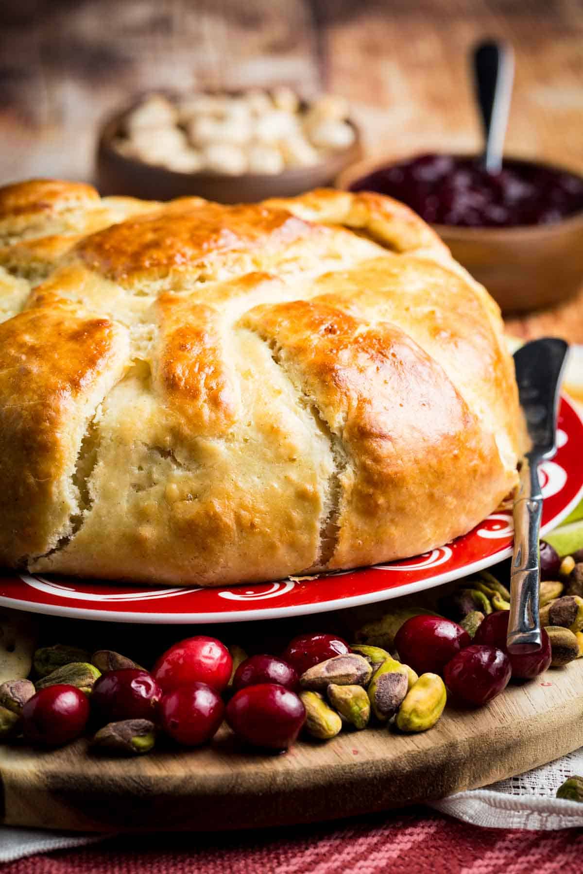 A serving platter holds a baked brie in crescent dough.