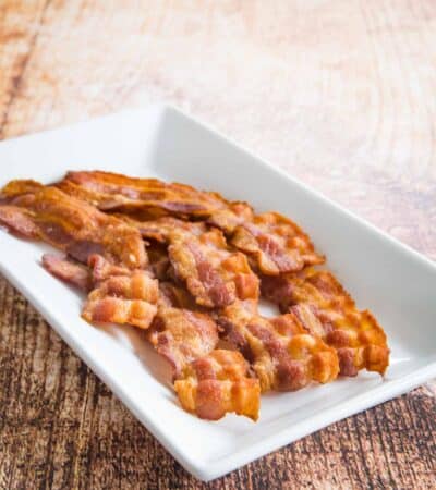 A plate of cooked bacon slices.