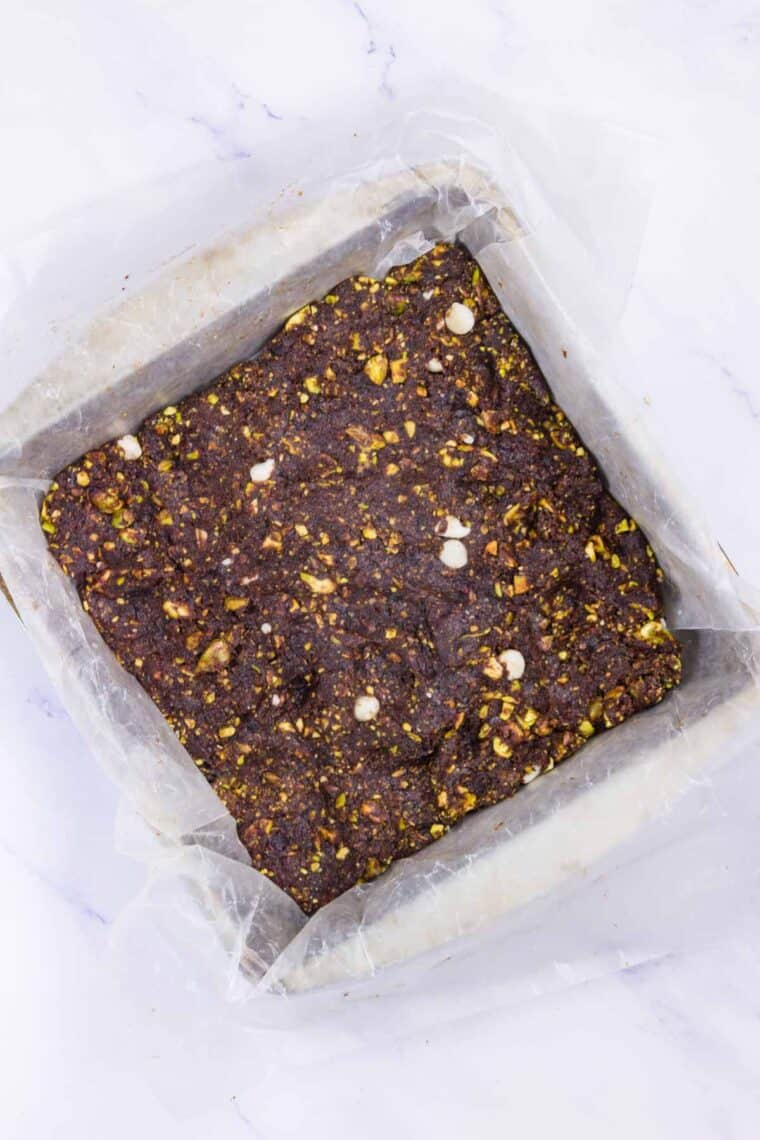 Cherry energy bars dough is pressed into a pan.