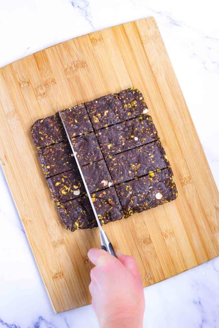 A knife cuts cherry energy bars into squares.
