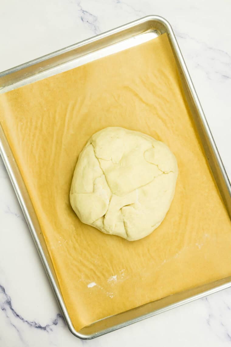 A package of brie in crescent dough on a baking sheet.