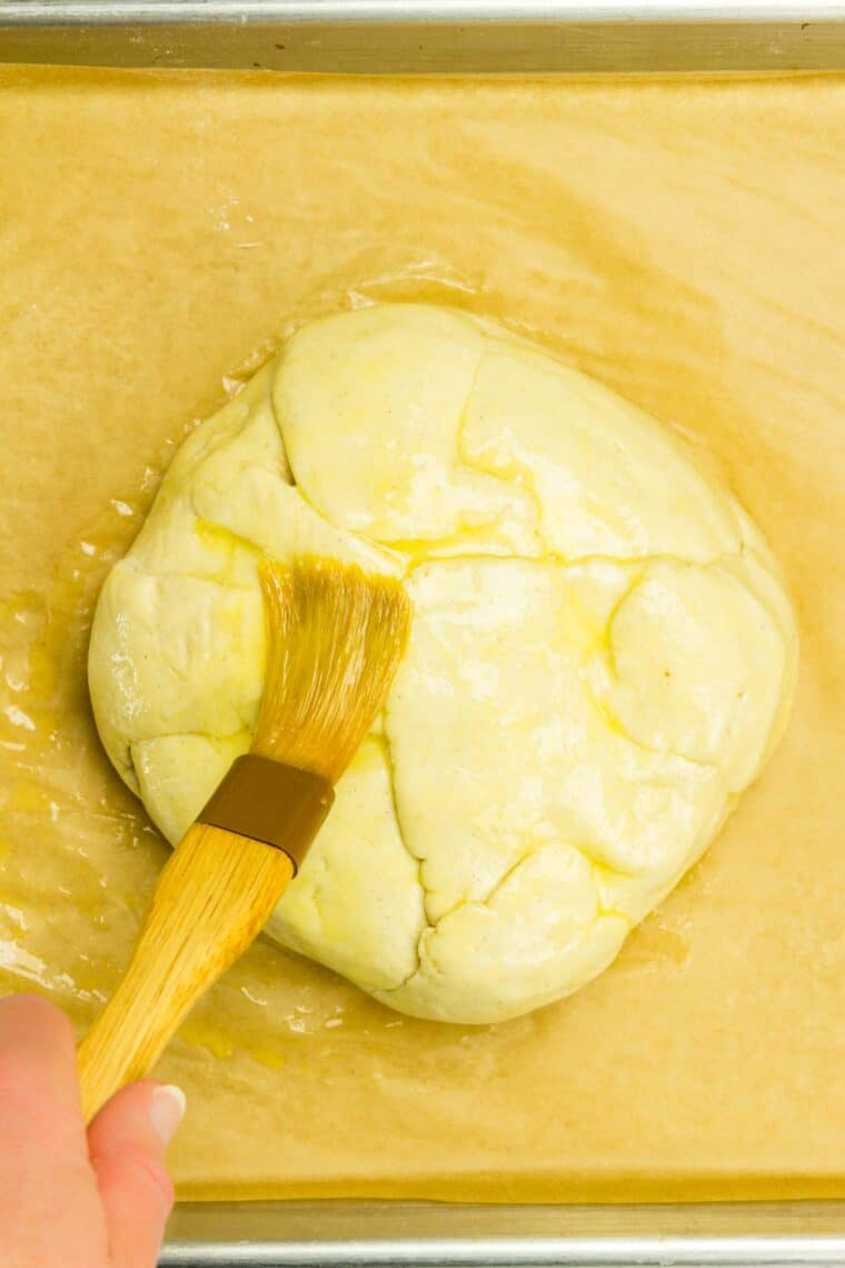 Brushing beaten egg onto crescent dough.