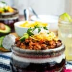 A crock of chili topped with cheese and sour cream with text overlay that says "Quick & Easy Chipotle Turkey Chili".