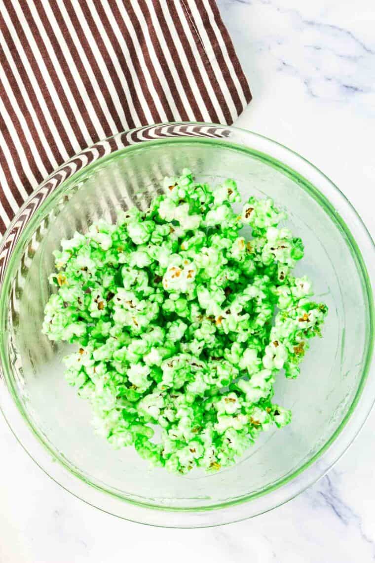 Popcorn is mixed with a green food coloring mixture.