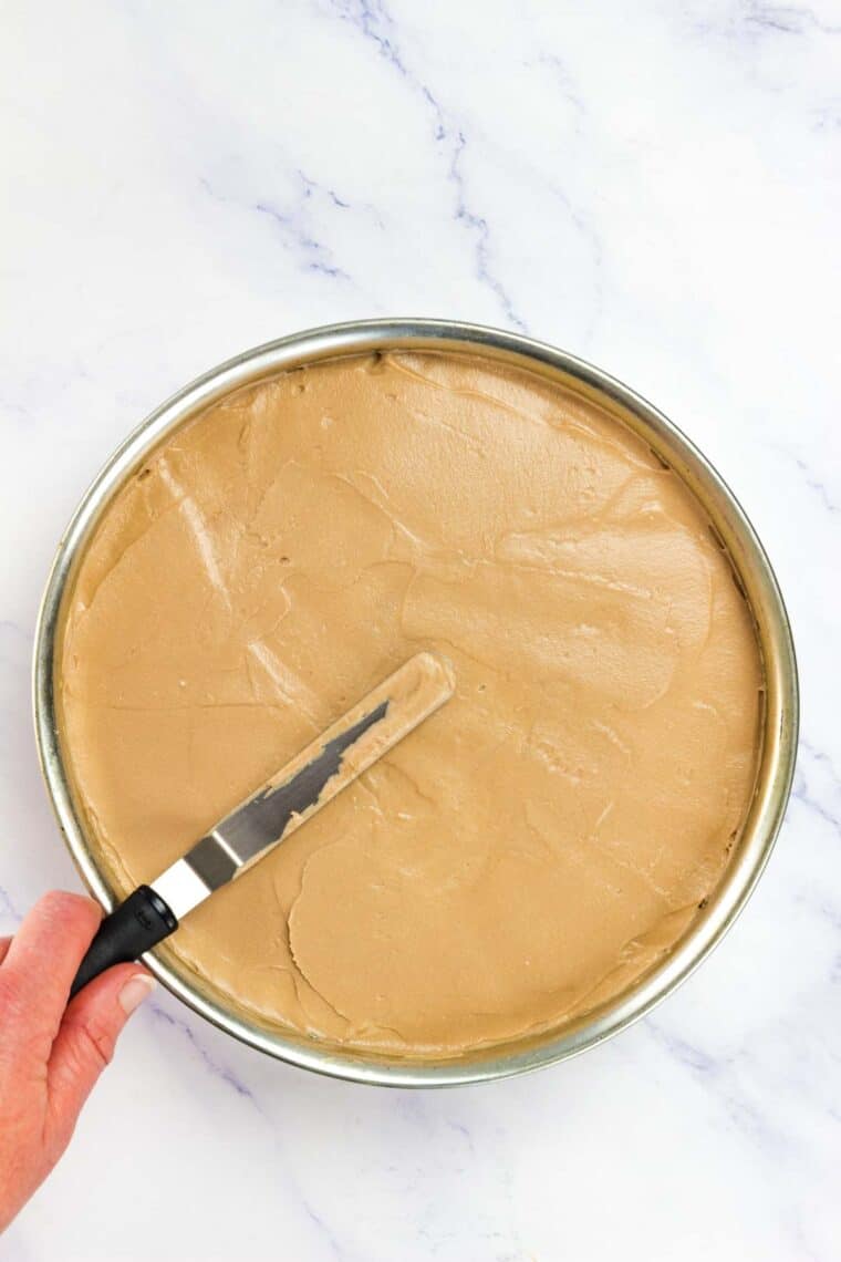 Nutella cheesecake filling is spread in a pan.