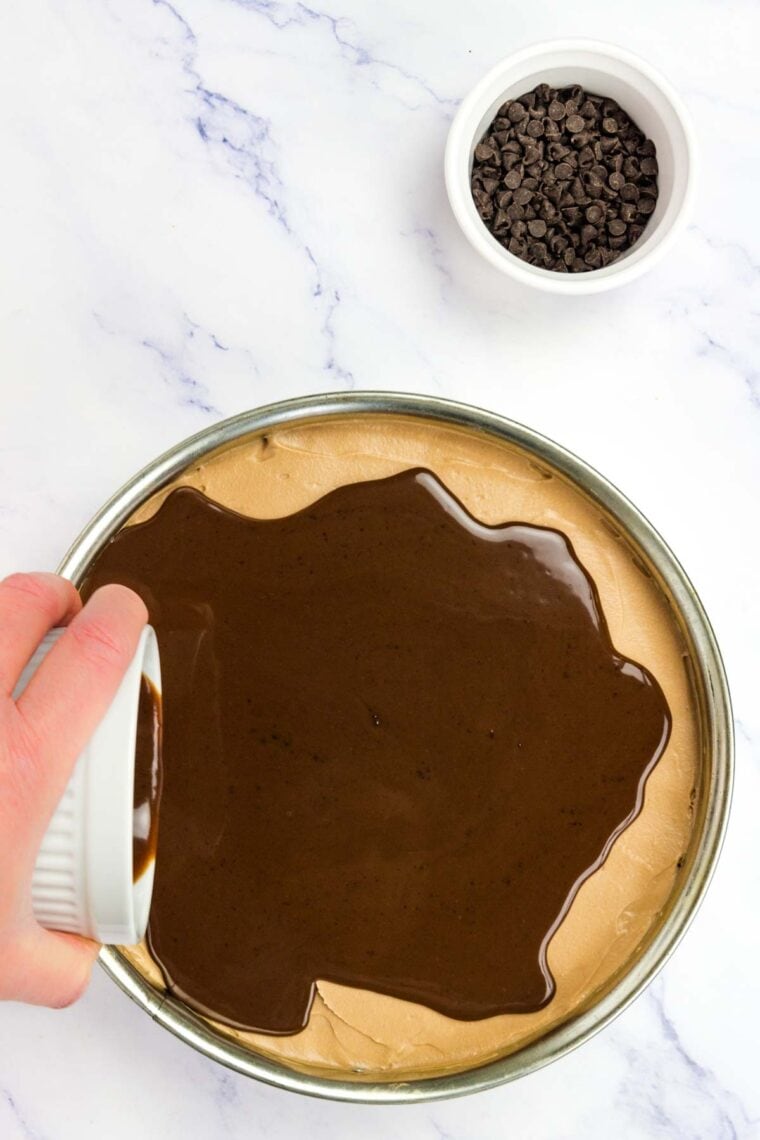 Chocolate ganache is poured over nutella cheesecake.