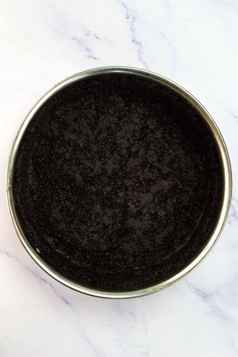An oreo pie crust in a springform pan.