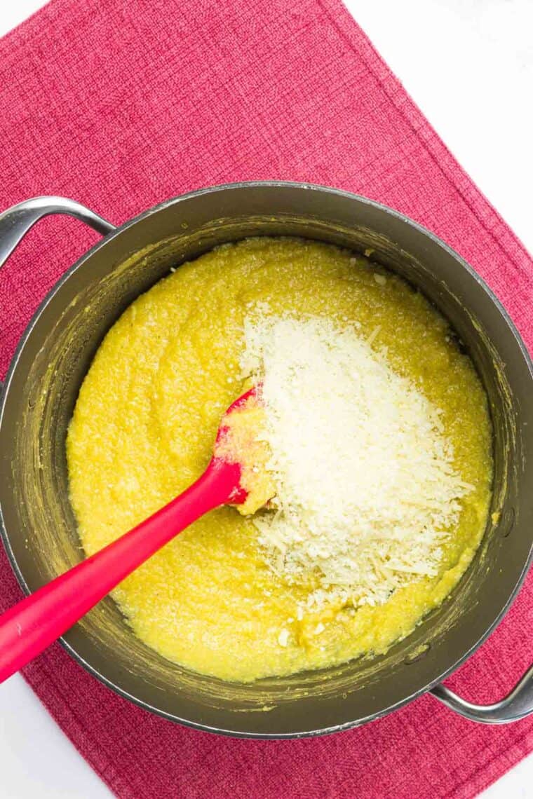 Parmesan cheese added to the pot of polenta.