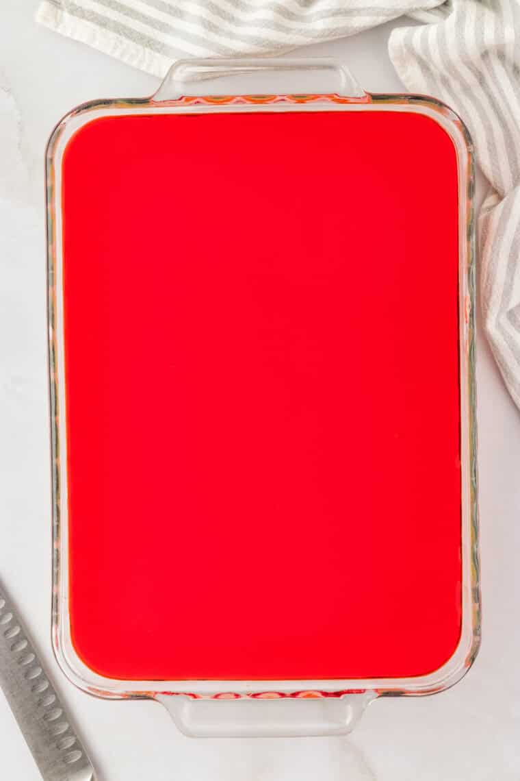 Another layer of cooled jello added on top of a white layer.