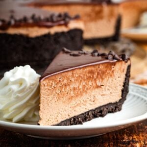 A scoop of whipped cream next to a slice of Nutella cheesecake.