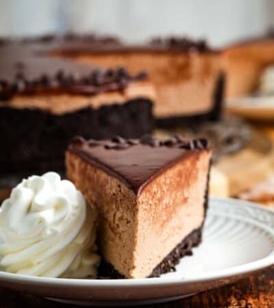 A scoop of whipped cream next to a slice of Nutella cheesecake.