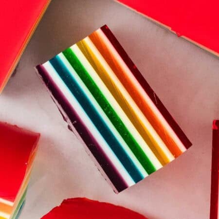 A square of layered rainbow jello on its side.