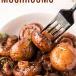 A fork in a bowl of balsamic-glazed mushrooms with text overlay that says "Roasted Mushrooms".