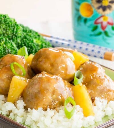 Teriyaki meatballs with pineapple served on a bed of rice.