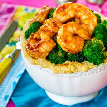 Shrimp and steamed broccoli on the top of a shrimp quinoa bowl.