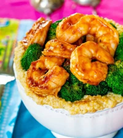 A white bowl of shrimp quinoa bowl with bbq shrimp.