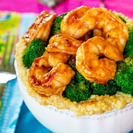 A white bowl of shrimp quinoa bowl with bbq shrimp.