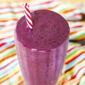 A closeup of the top of a cherry smoothie in a glass.