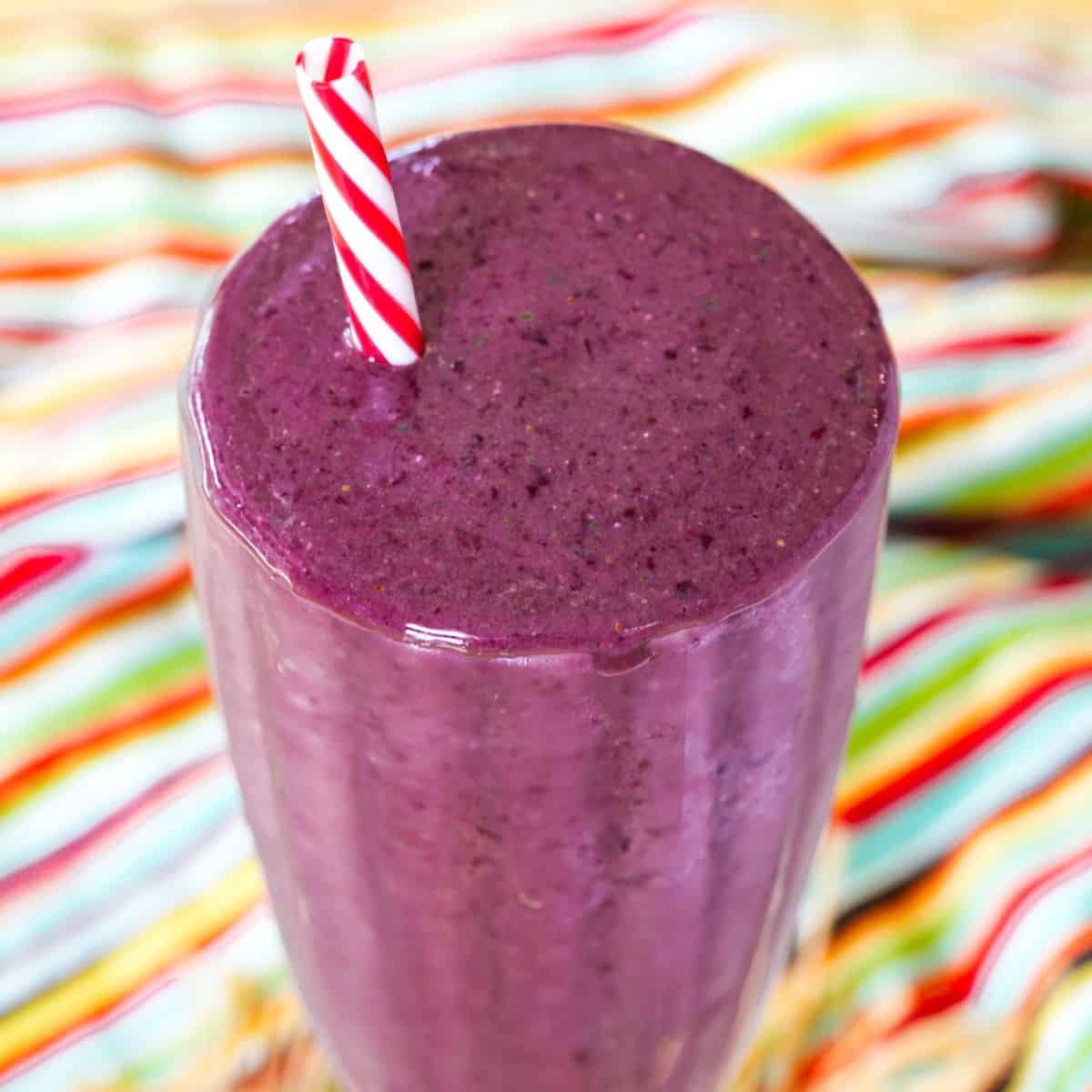 A closeup of the top of a cherry smoothie in a glass.