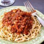 A plate of pasta topped with a sauce with veggies and chickpeas with text overlay that says "Chickpeas in Tomato Sauce".