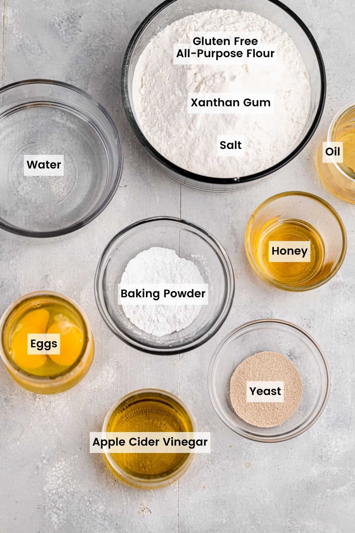 Glass bowls with ingredients for gluten free bread with text labels.