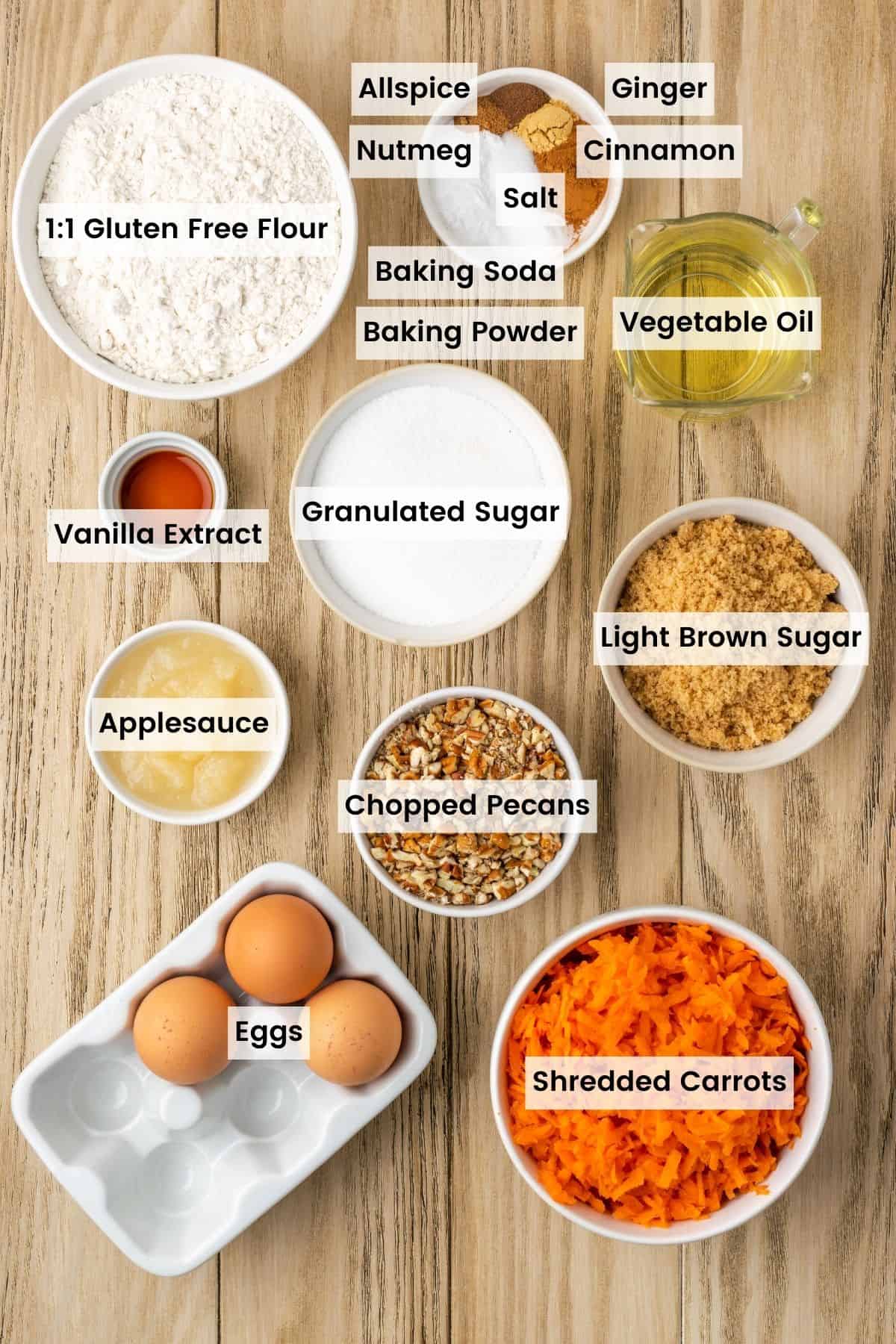 Gluten free carrot cake ingredients portioned out in bowls on a table with text labels.