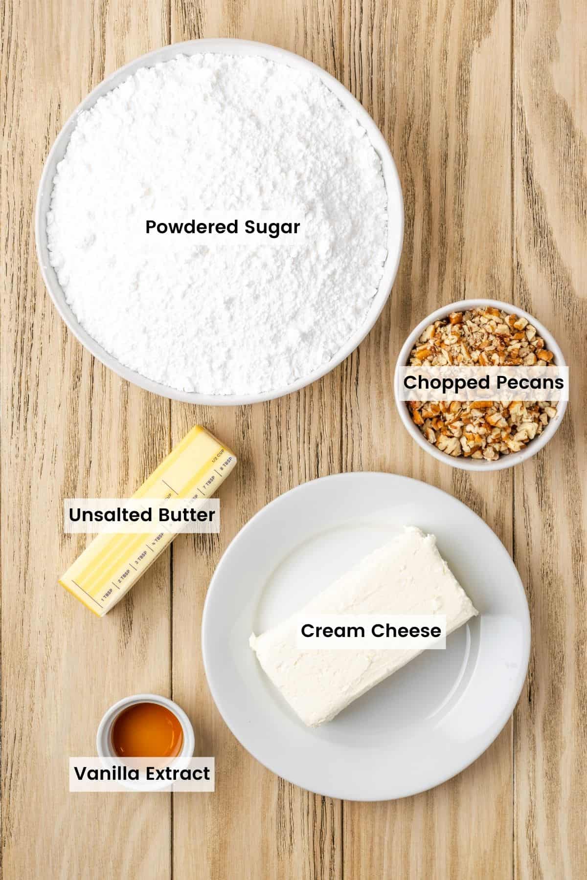 Cream cheese frosting ingredients portioned out in bowls on a table with text labels.