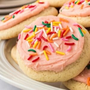 A closeup of a gluten free lofthouse cookie with pink frosting and sprinkles.